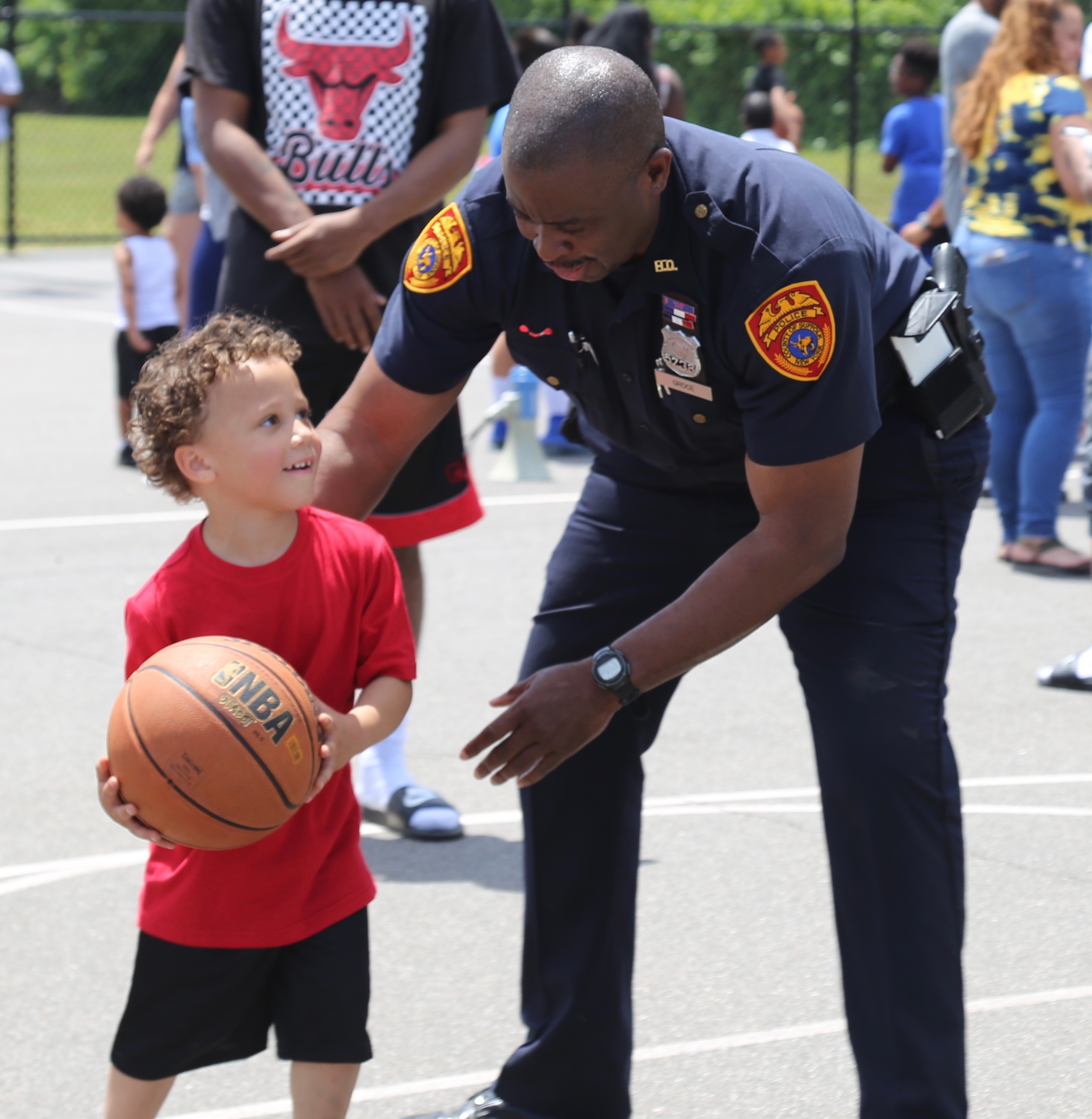 a policeman and a young boy playing baseball